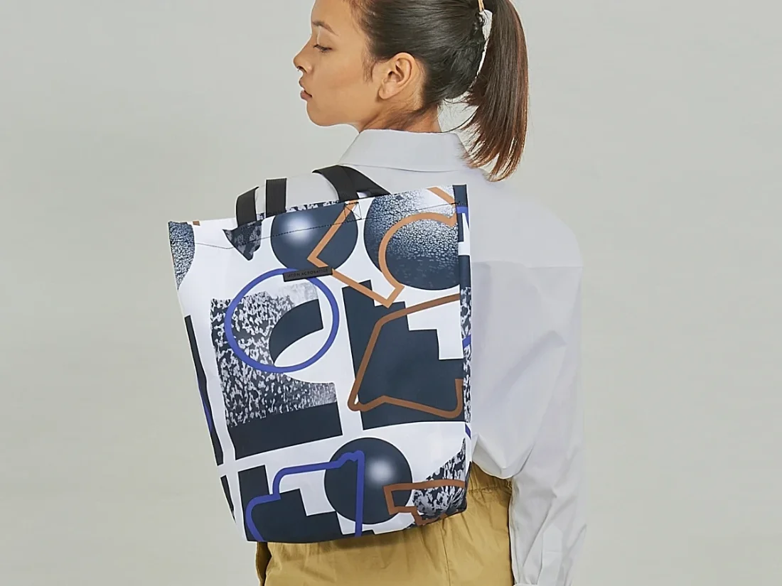 Mannequin holding a Ucon Acrobatics bag on its back with a pattern signed by My Name is Wendy
