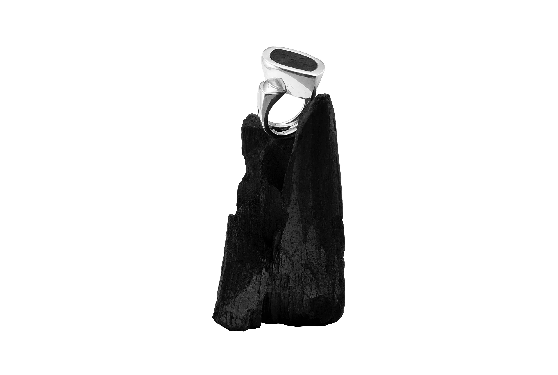 On white background, silver ring on coal